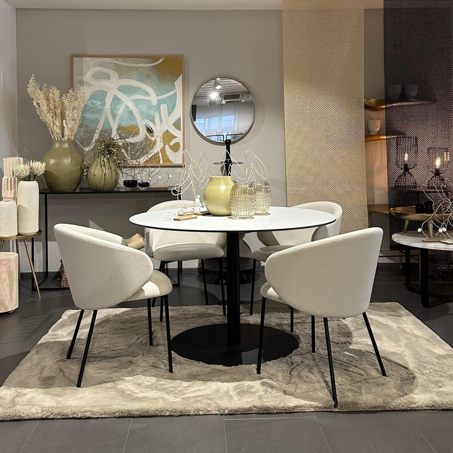 Elegante Essgruppe mit rundem weißem Tisch, beigen Stühlen und abstraktem Landschaftsbild in warmen Naturtönen.