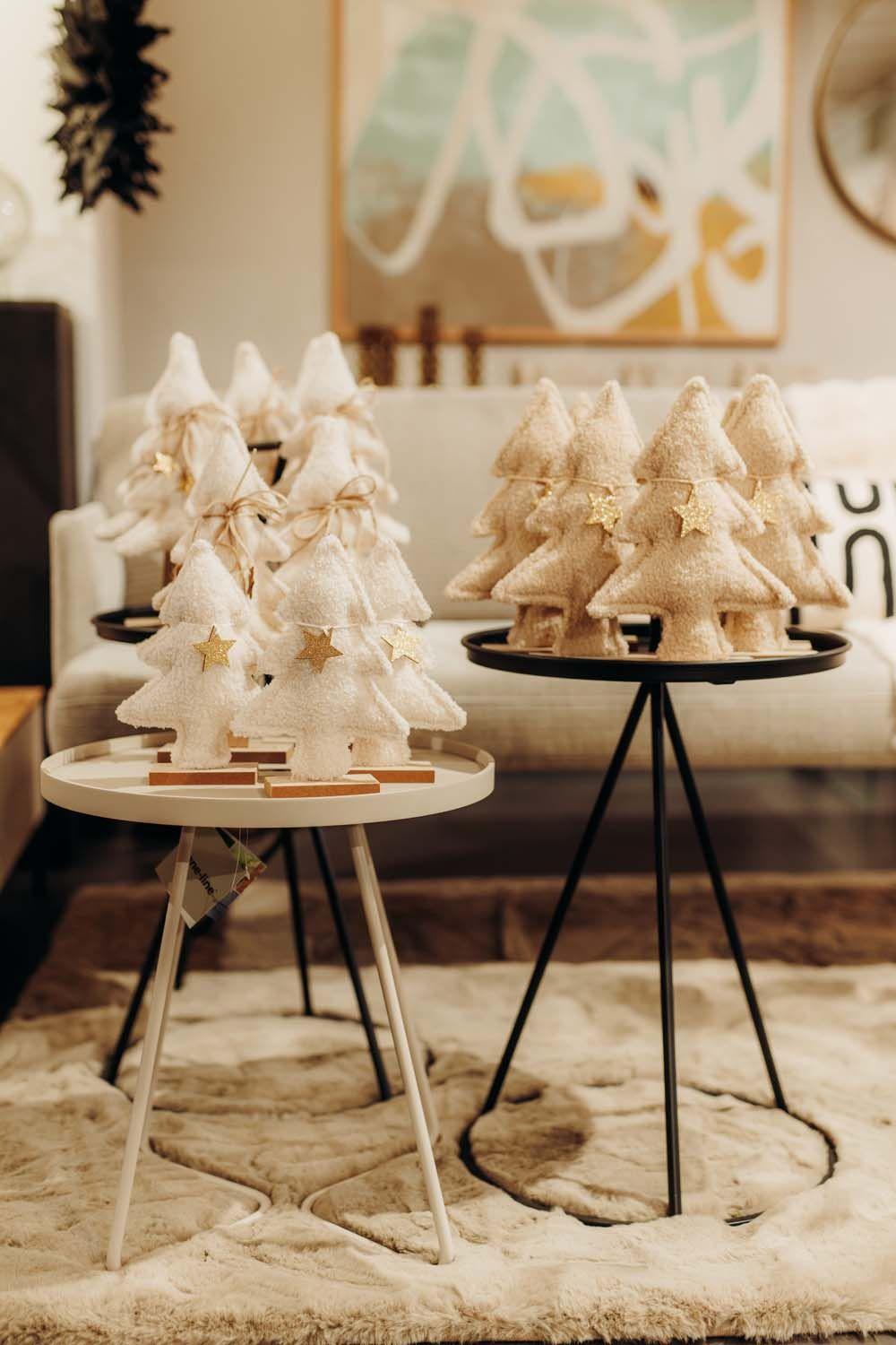 Stilvolle Weihnachtsbäume aus Holz und Stoff in natürlichen Farbtönen auf modernen Beistelltischen bei Möbel Grell.