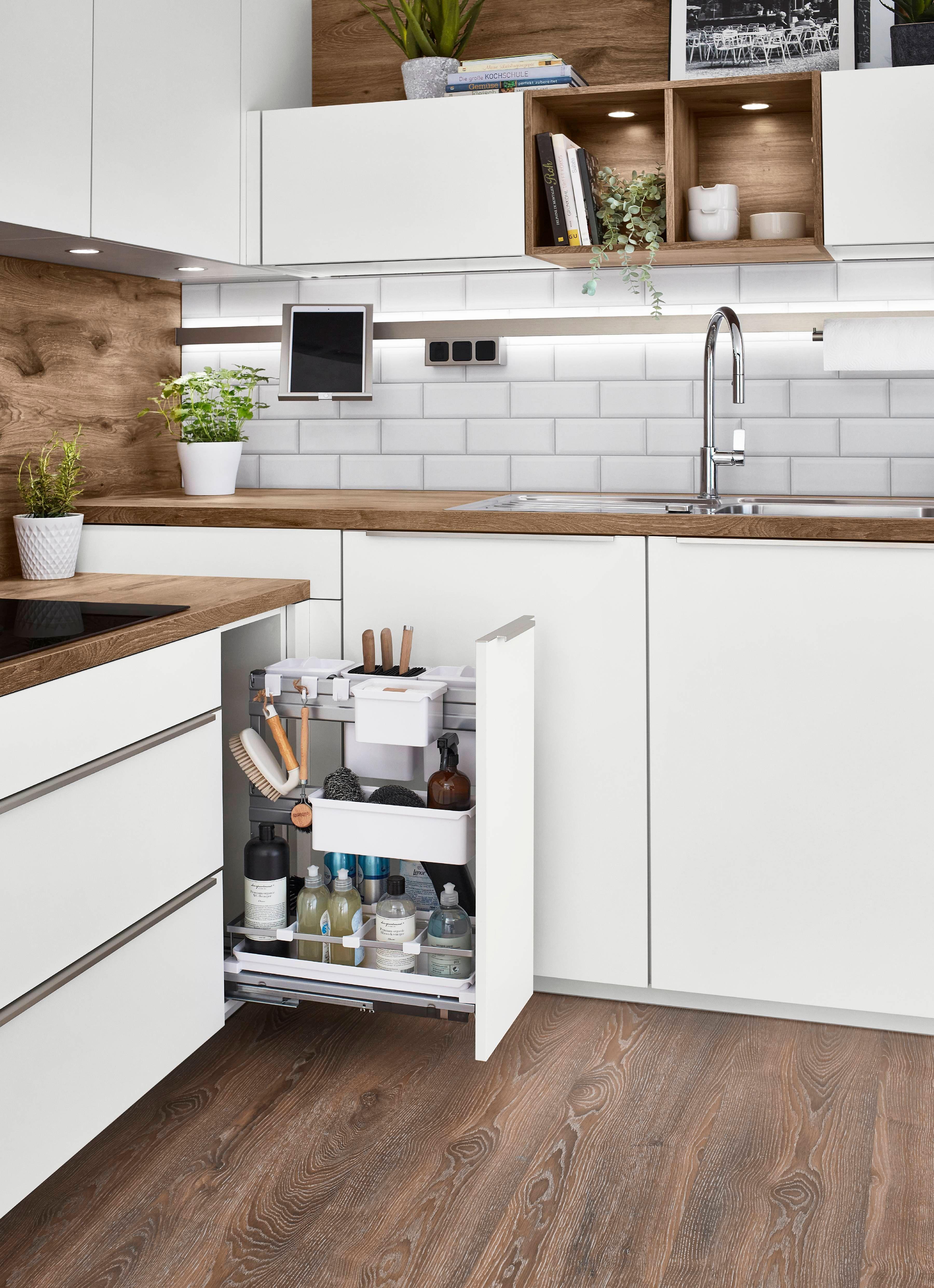 L-Küche mit ausziehbarem Regal für Küchenutensilien und Reinigungsmittel.