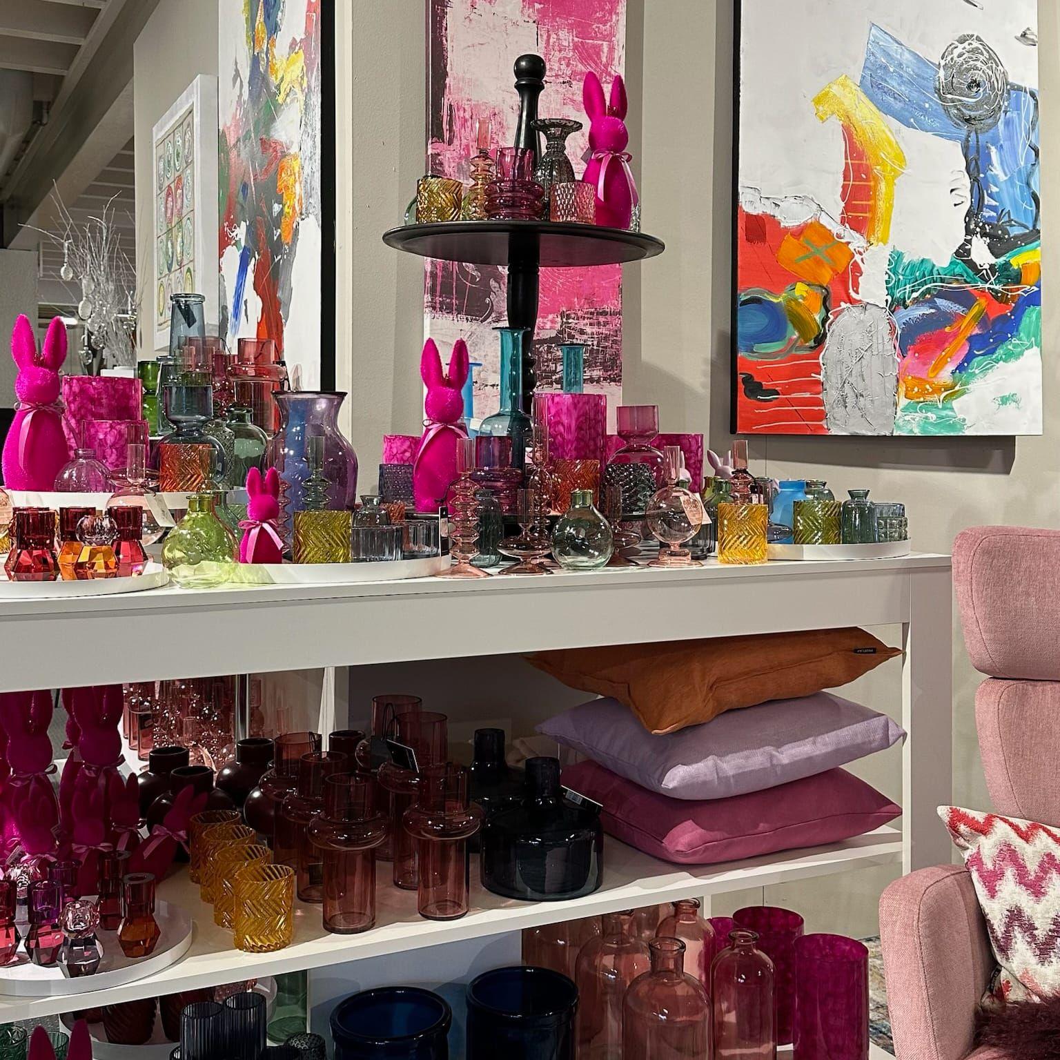 Detailansicht der farbenfrohen Deko mit pinken Hasen, bunten Windlichtern und moderne Kunstwerke im Hintergrund.