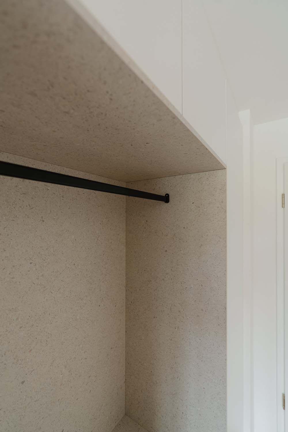 Seitliche Ansicht der beplankte Garderobennische mit schwarzem Kleiderbügel.