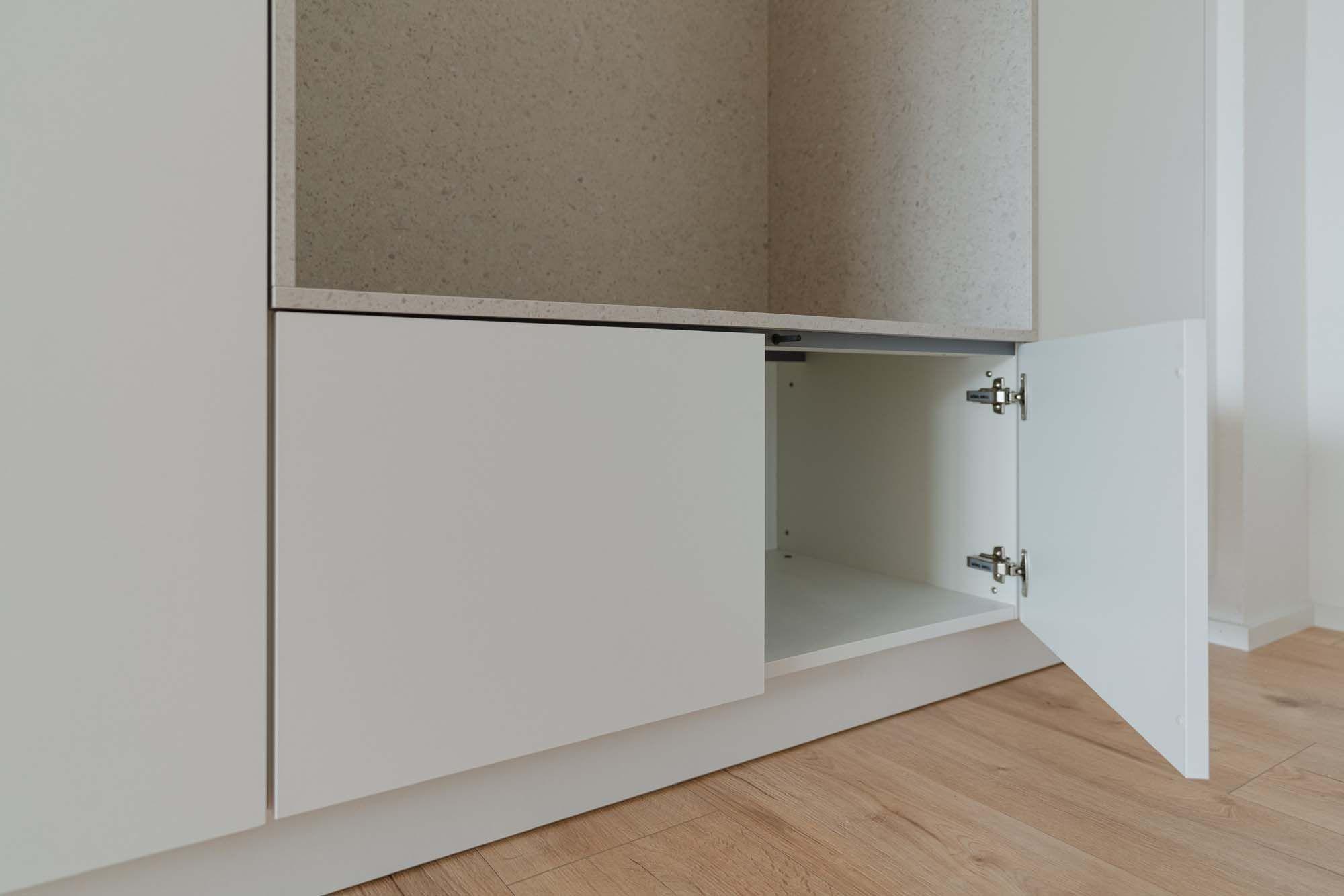 Geöffneter Unterschrank der Garderobenzeile mit weißem Innenraum.