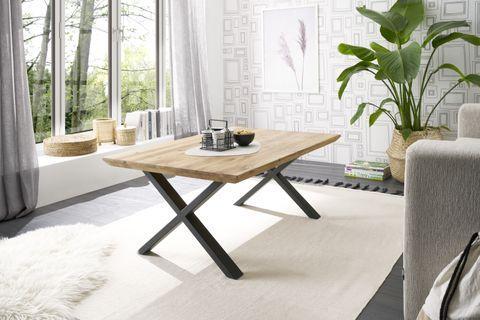 Moderner Esstisch mit massiver Holzplatte und X-Gestell aus Metall – helles, freundlich eingerichtetes Esszimmer mit großen Fenstern und Naturblick.
