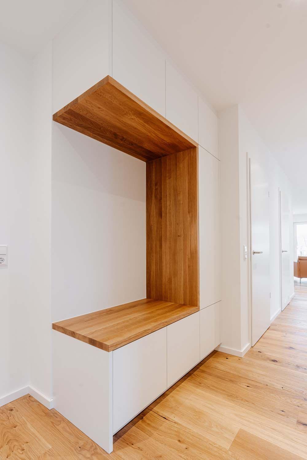 Maßgefertigte weiße Garderobe mit eingebauter Eichennische, Sitzbank und Stauraum im Eingangsbereich