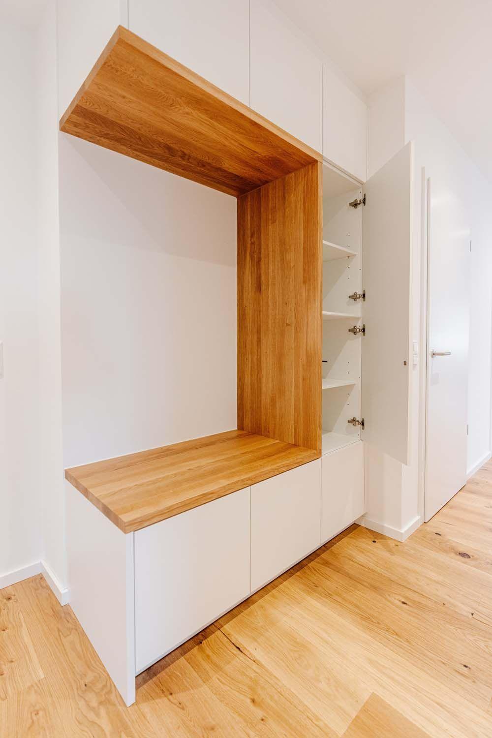 Einbaugarderobe mit geöffneter Tür zeigt Einlegeböden, Eichennische und weiße Fronten auf Holzboden