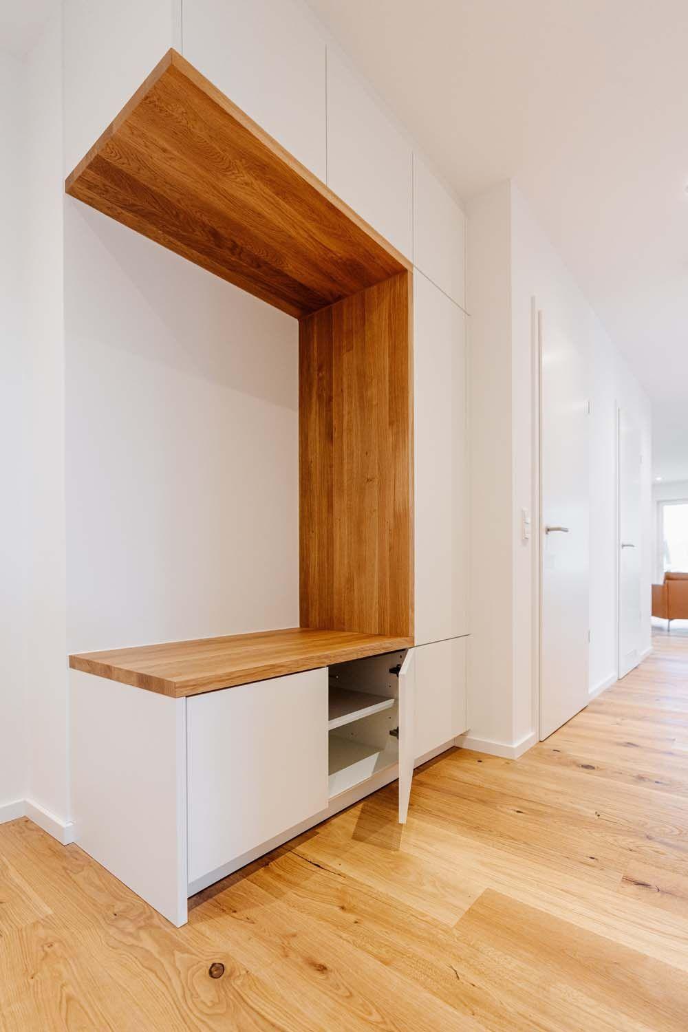 Flurgarderobe mit Eichennische, geöffneter weißer Schranktür mit Einlegeböden und Holzparkett.