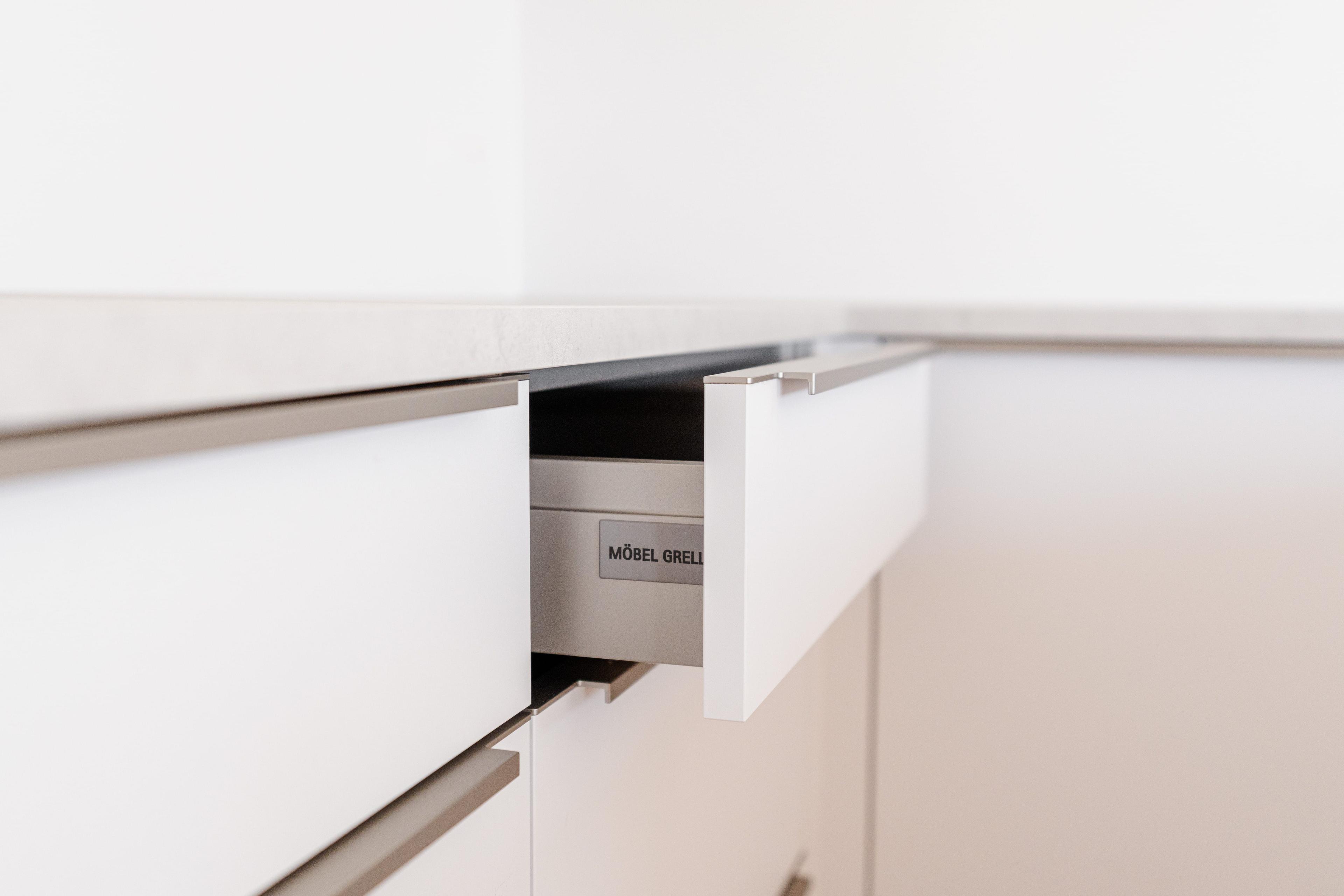 Geöffnete Küchenschublade mit Soft-Close-System und Möbel Grell Beschriftung im Inneren.