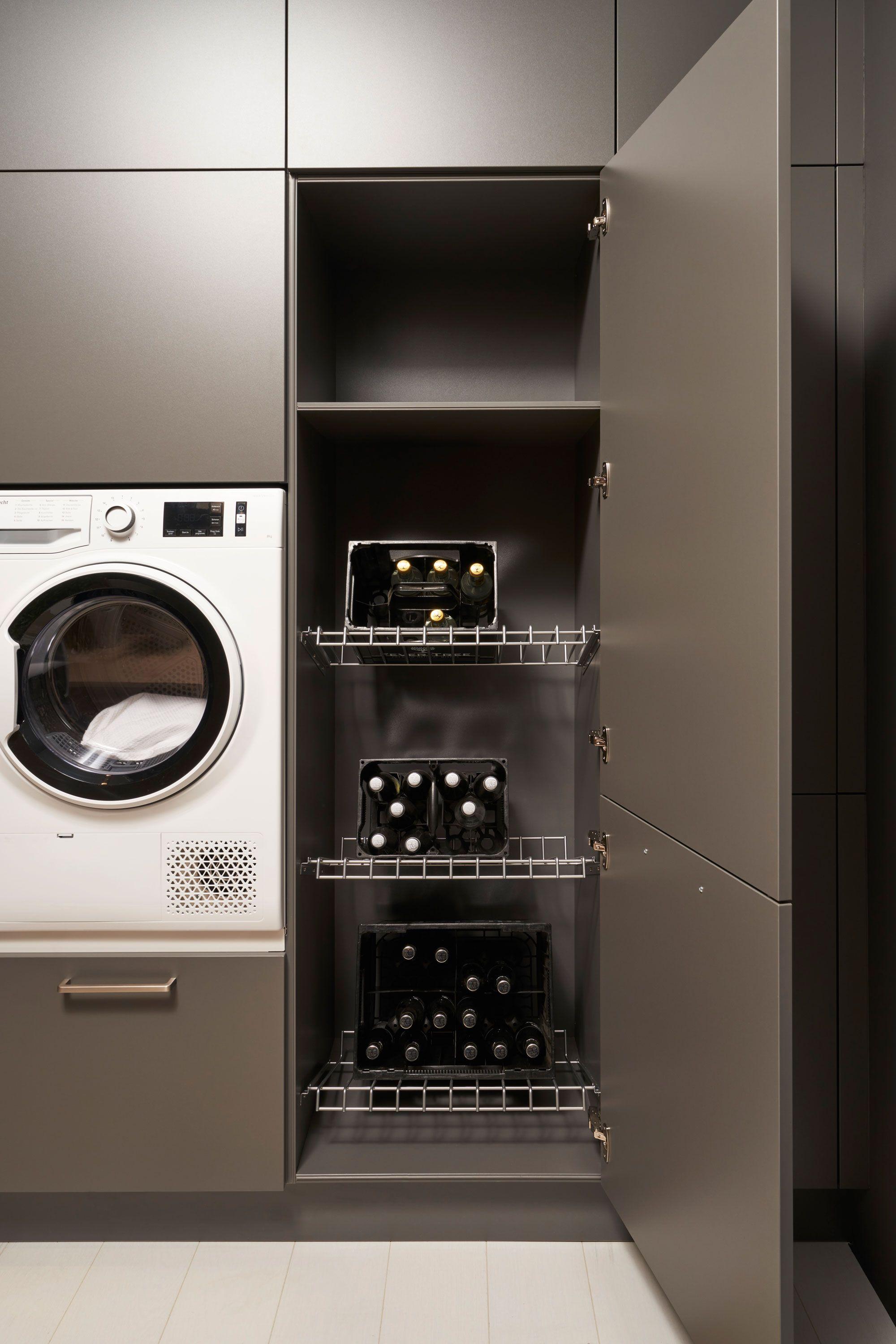 Hauswirtschaftsraum-Schrank mit integrierten Weinregalen und ausziehbaren Flaschenhaltern neben einer weißen Waschmaschine.