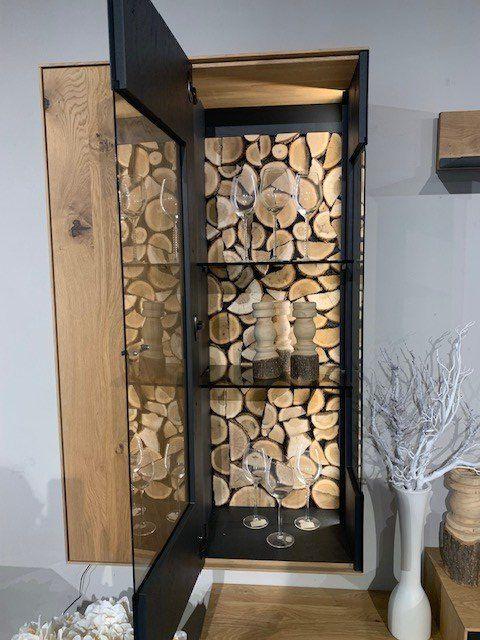 Geöffneter Holzschrank mit sichtbarem Brennholzvorrat und integrierter Beleuchtung.