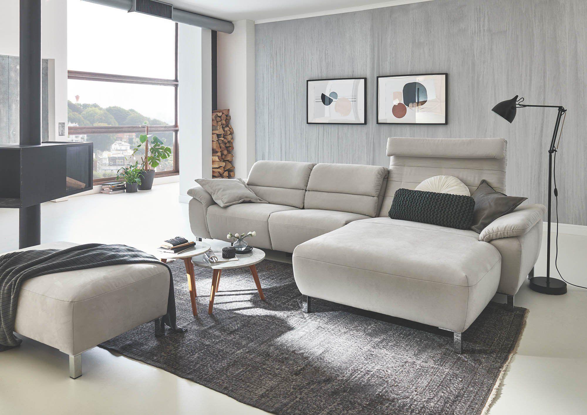 Elegante graue Eckcouch mit erhöhten Kopfstützen und modernem Couchtisch in minimalistischem Wohnraum.