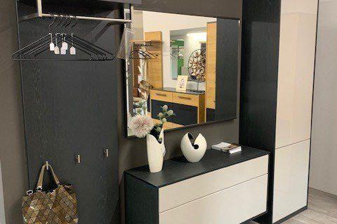 Moderne Garderoben-Wohnwand in anthrazit-weiß mit geöffnetem Kleiderschrank, Spiegel und Schublade.