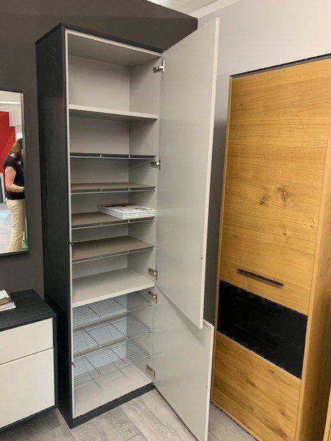 Geöffneter Hochschrank der Garderobenwand zeigt weiße Innenausstattung mit Regalbrettern und Kleiderstange.