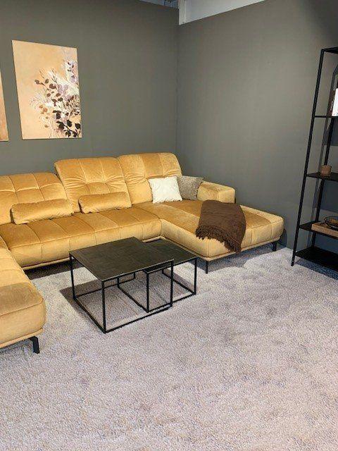 Modulare gelbe Ledergarnitur mit Hocker und Industrial-Couchtischen unter Dachschräge.