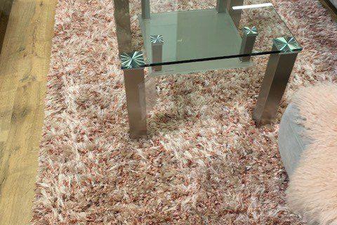 Glas-Couchtisch mit Edelstahlbeinen und zwei Glasplatten vor weißem Hintergrund, Produktfoto.