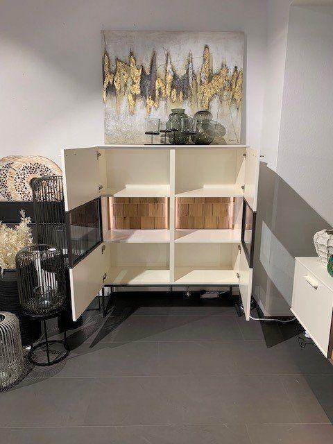 Highboard mit geöffneten Türen zeigt Innenaufteilung mit Holzrückwand und Glasböden.