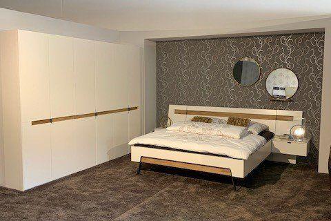 Modernes Schlafzimmer mit weißem Schwebebett, großem weißen Kleiderschrank mit Holzgriffen und Panoramafenster.