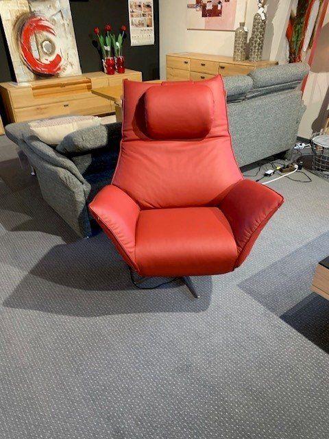 Roter Leder-Relaxsessel mit hoher Rückenlehne auf Drehgestell in Möbelhaus-Ausstellung.
