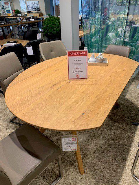 Ovaler Esstisch aus Eichenholz mit modernen grauen Stühlen und rotem Abverkaufs-Preisschild in Showroom.