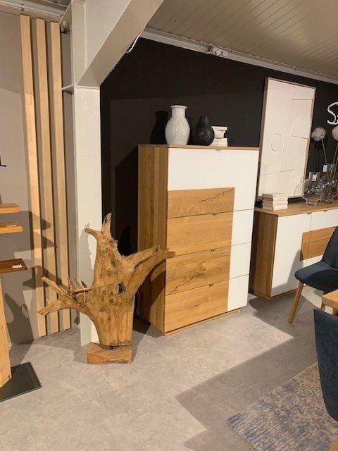 Highboard aus Holz und Weiß mit mehreren Schubladen in Möbelhaus-Ausstellung.