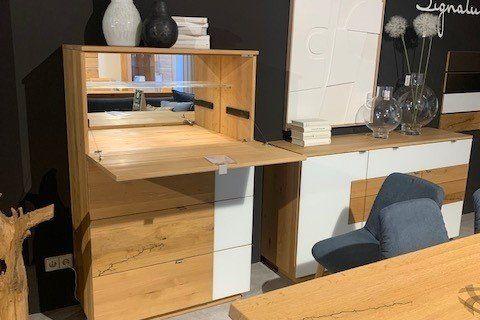 Highboard aus Holz und Weiß mit mehreren Schubladen in Möbelhaus-Ausstellung.