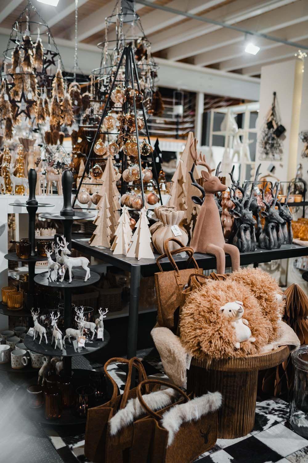 Weihnachtlich dekorierter Tisch mit Holzbäumen, Rentierfiguren und warmen Naturtönen.