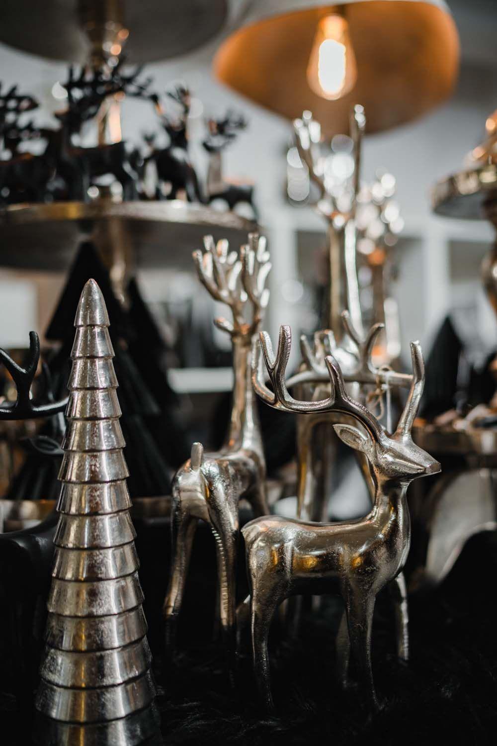 Silberfarbene Rentier- und Tannenbaumfiguren als elegante Weihnachtsdekoration.