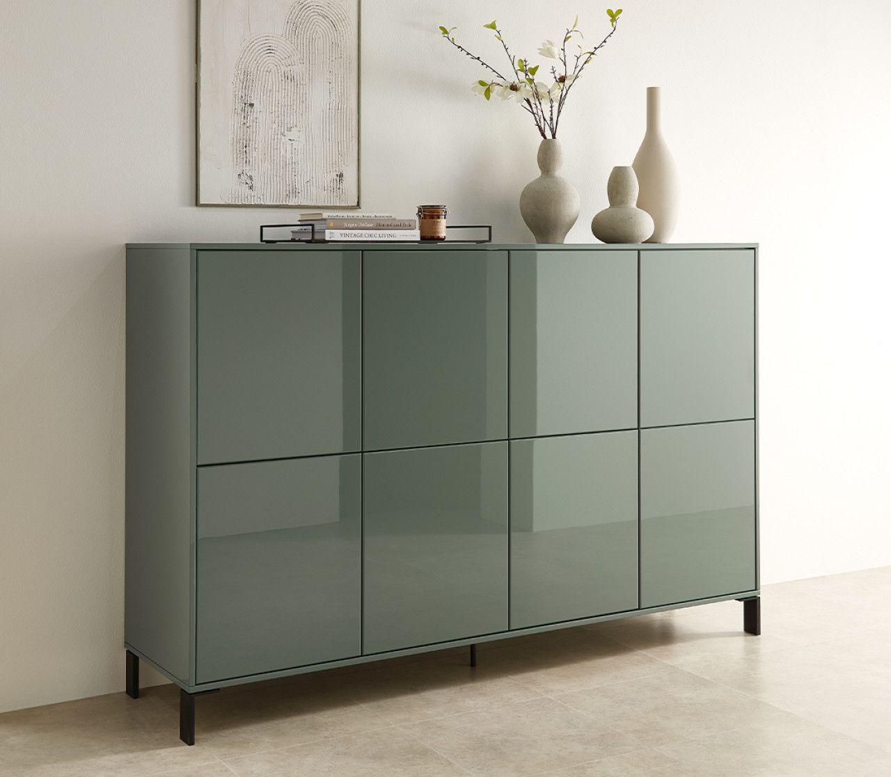 Glänzende Kommode in Salbeigrün mit schwarzen Füßen und schlichter Dekoration